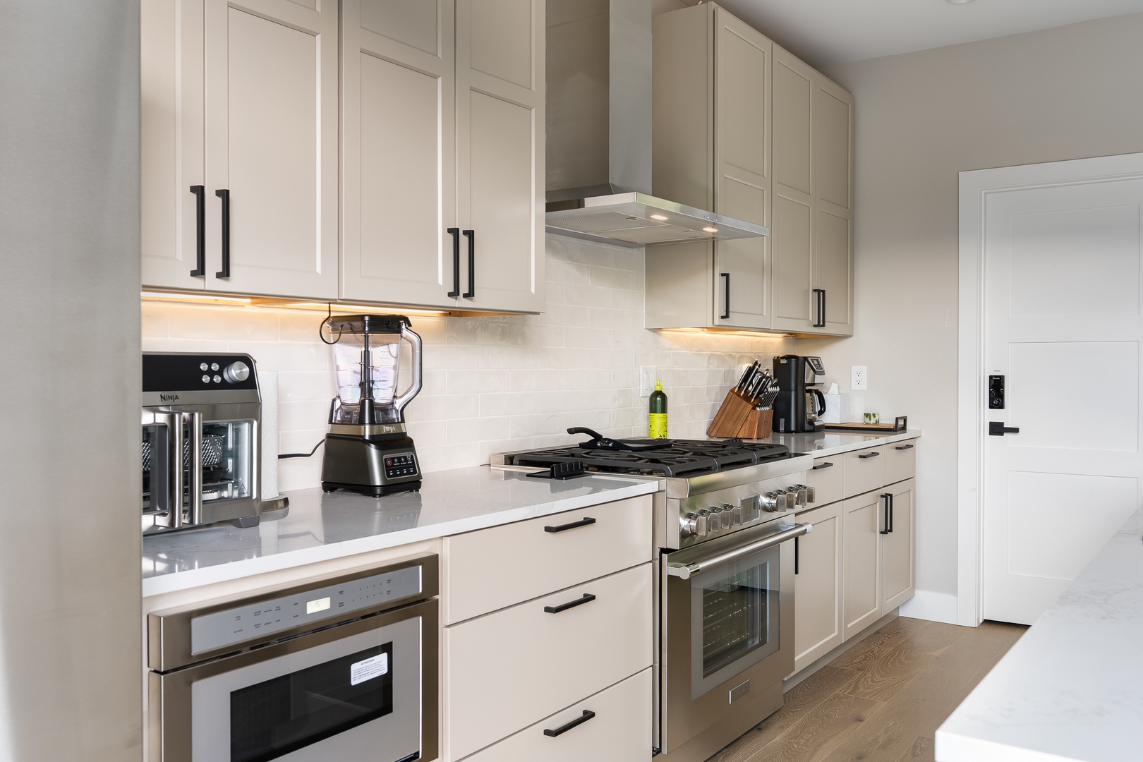 This sleek kitchen has everything you need, from a gas range and built-in oven to Air Fryer, Ninja Blender and Drip Coffee with grinder