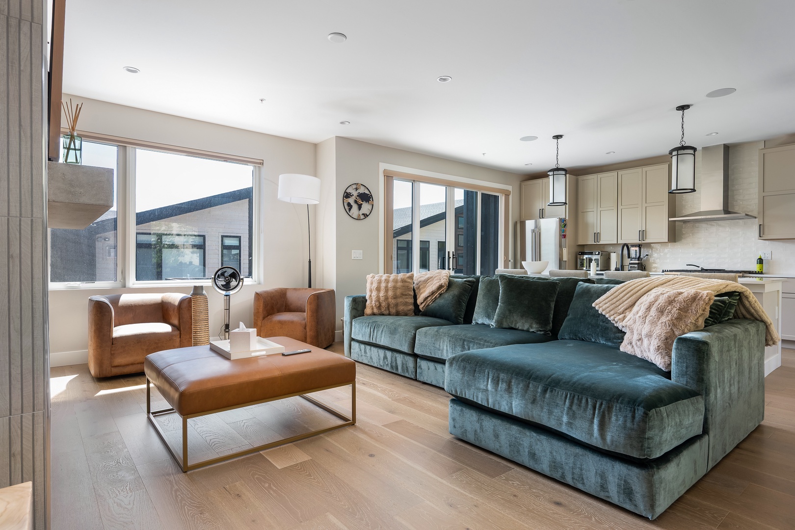 Sink into the plush velvet sofa and let natural light fill this open-concept living space. Your fully equipped kitchen awaits just steps away, perfect for preparing meals while staying connected to your group.