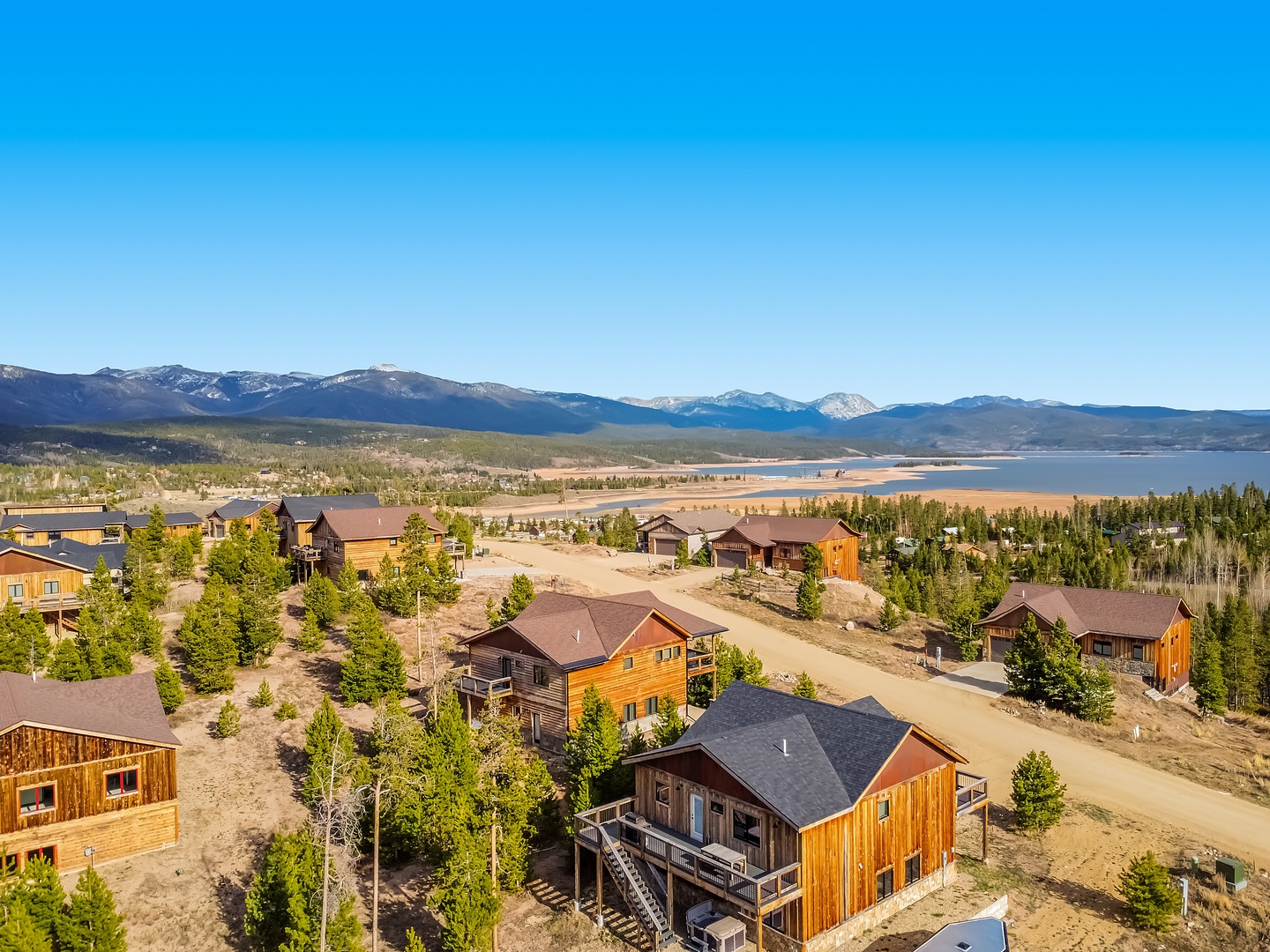 Aerial view of a mountain community nestled between pristine wilderness and stunning lake vistas beneath endless Colorado skies.