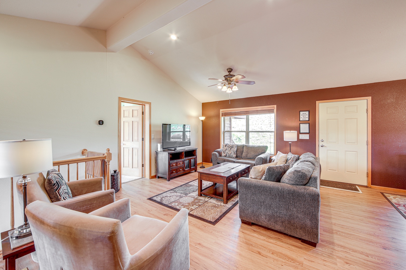 Relax in your spacious living room with vaulted ceilings, cozy sectional seating, and warm natural light streaming through large windows.