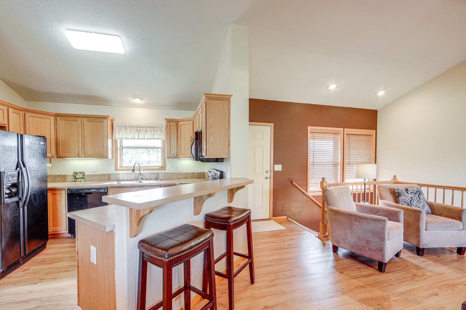 Your spacious kitchen and living area blends comfort with functionality, featuring warm wood tones and modern appliances perfect for your getaway.