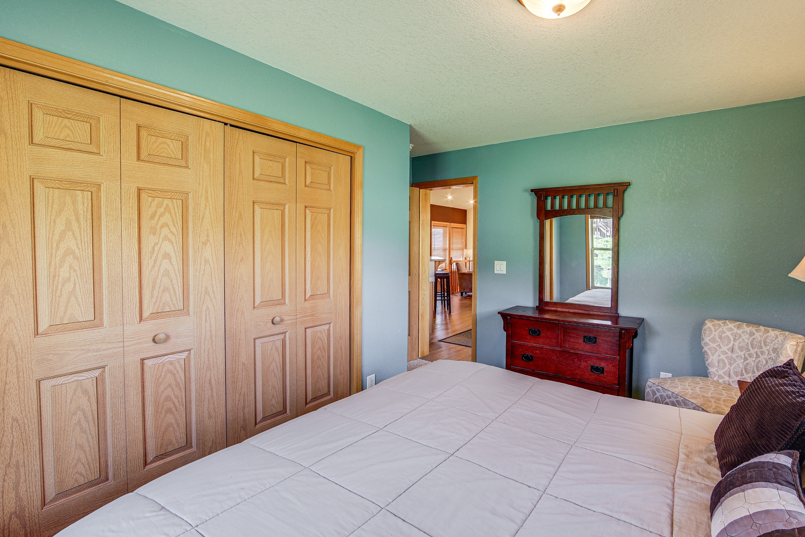 Relax in your peaceful bedroom with soothing teal walls, rich wood furnishings, and ample closet space for your belongings.