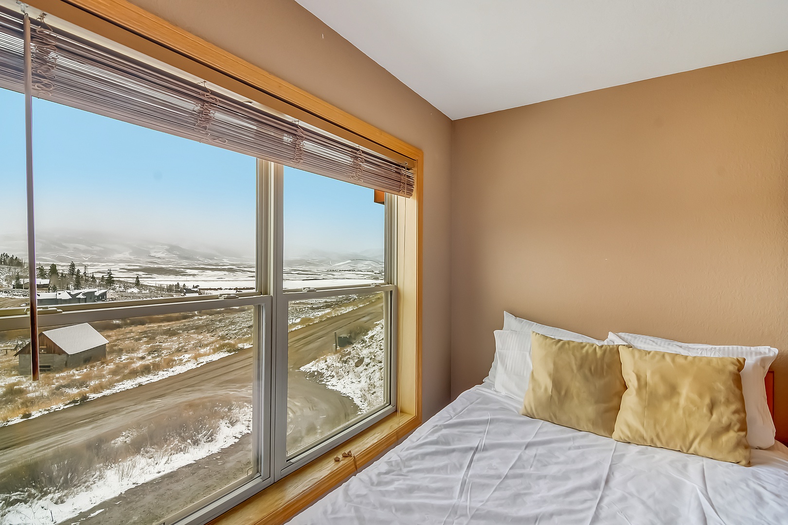 Wake up to stunning winter landscapes from your cozy bedroom, where warm linens and panoramic views create the perfect mountain retreat.
