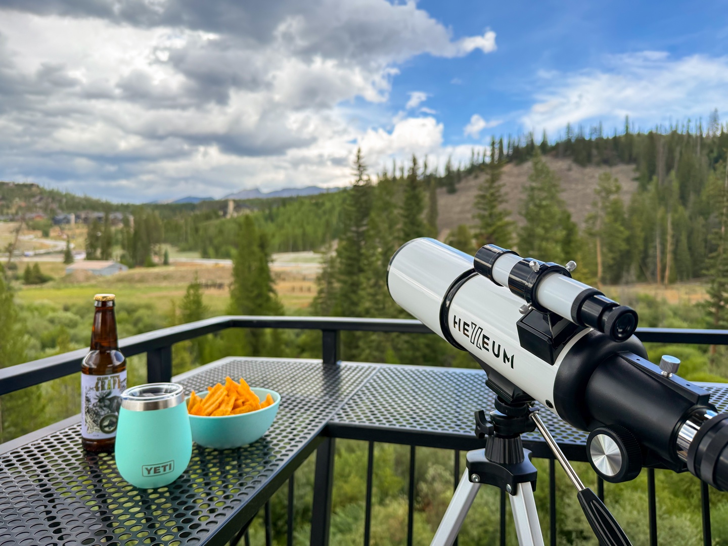 Your private balcony overlooks a stunning forested valley surrounded by mountains, perfect for sipping morning coffee or enjoying an evening beverage while stargazing with the telescope provided.
