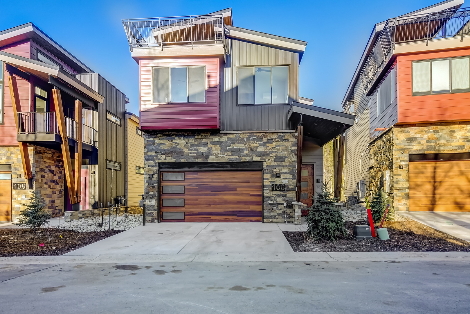 Modern townhomes with stone and wood accents create a striking architectural landscape in this contemporary neighborhood development.