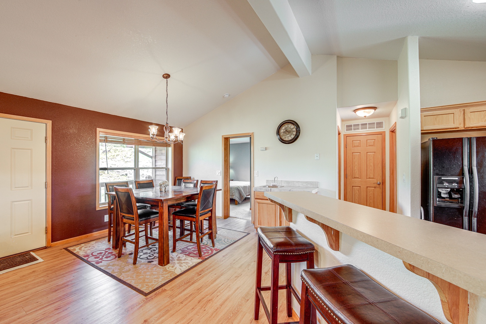 Your open-concept kitchen and dining space features warm wood finishes, modern appliances, and a breakfast bar perfect for morning coffee or casual meals.