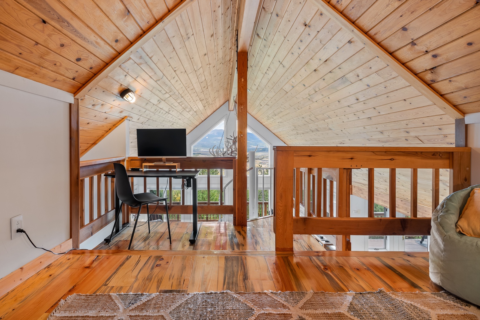 Cozy up in your lofted retreat with soaring wood-beamed ceilings and warm hardwood floors. A dedicated workspace invites remote days with sweeping natural light and peaceful mountain vistas.