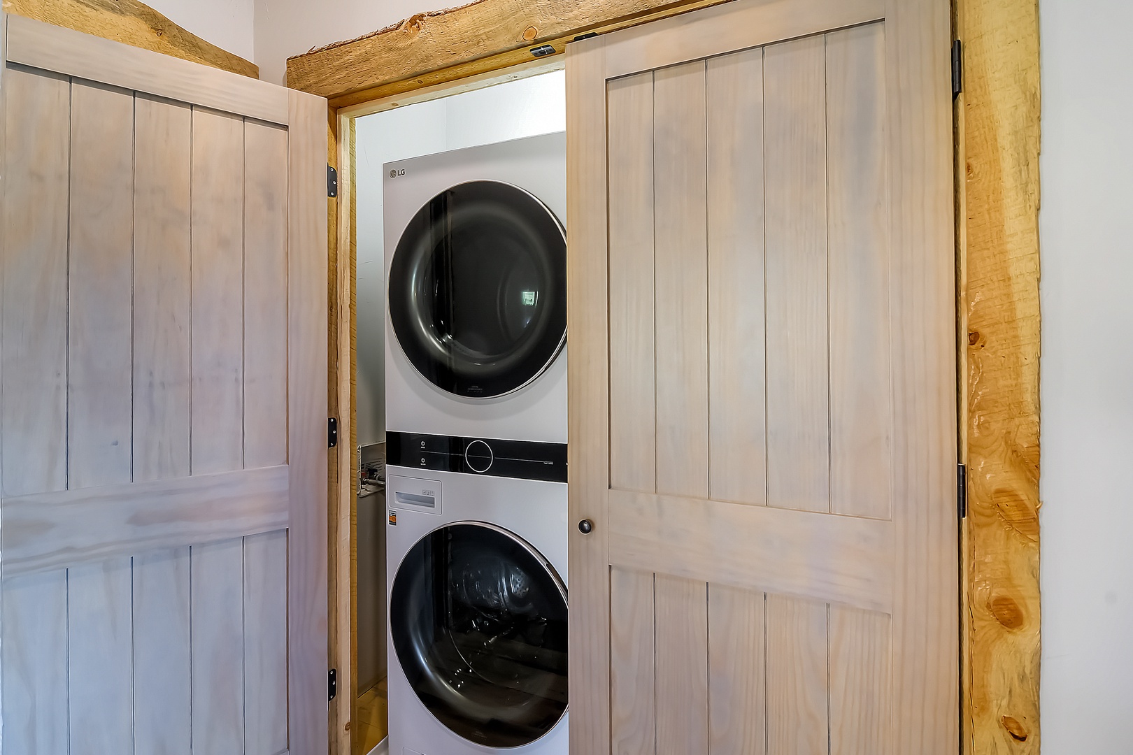 Your in-unit washer and dryer hide behind charming wooden doors, blending modern convenience with rustic style.