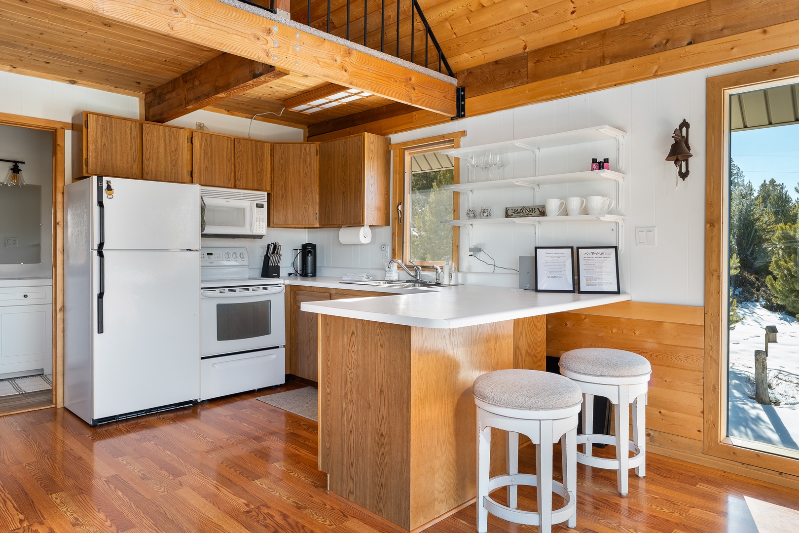 Rustic warmth meets modern convenience in your fully equipped kitchen, where exposed beams and rich wood create the perfect mountain retreat atmosphere.