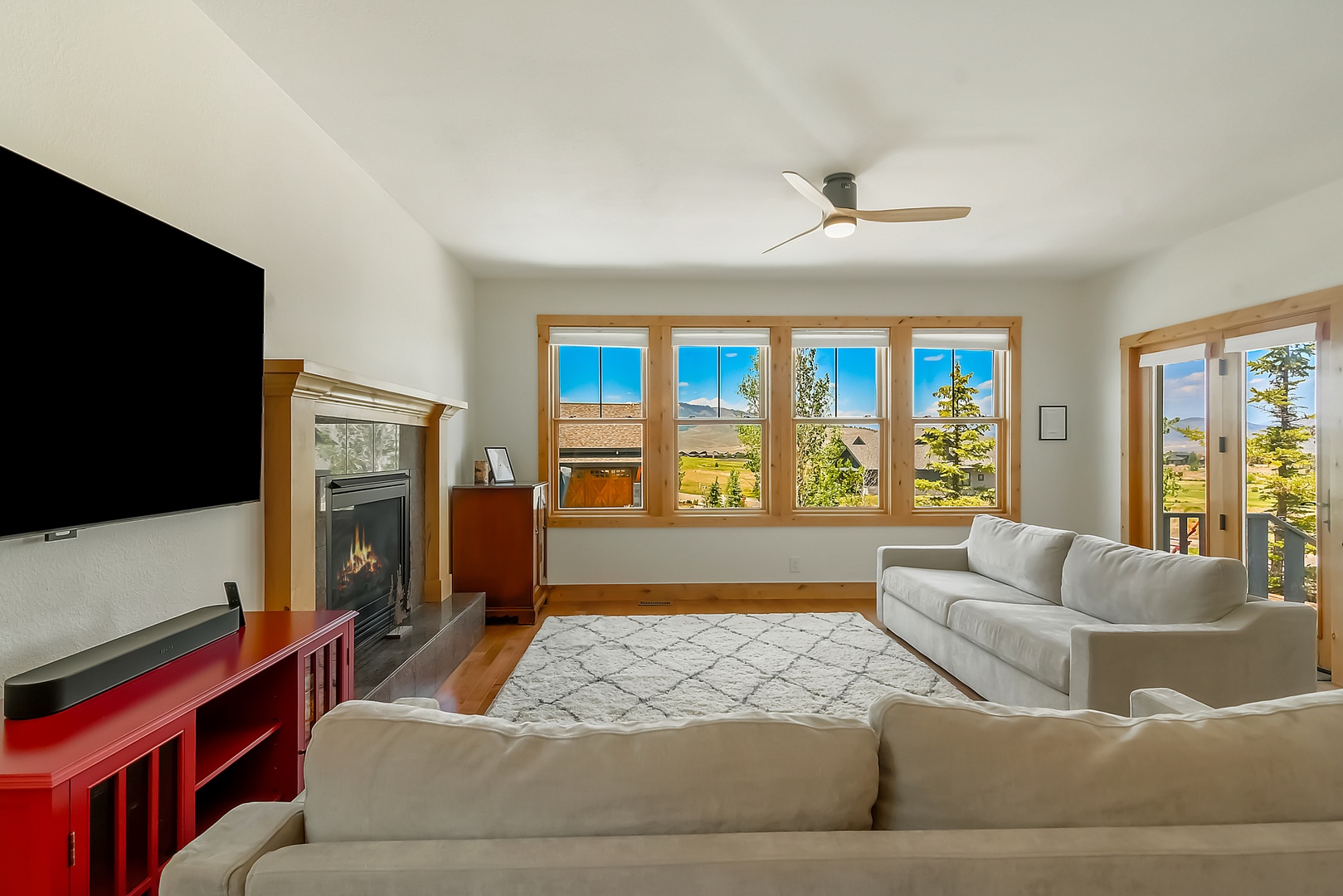 Relax in your bright living space with plush seating, a cozy fireplace, and sweeping views of mountains and meadows from every angle.