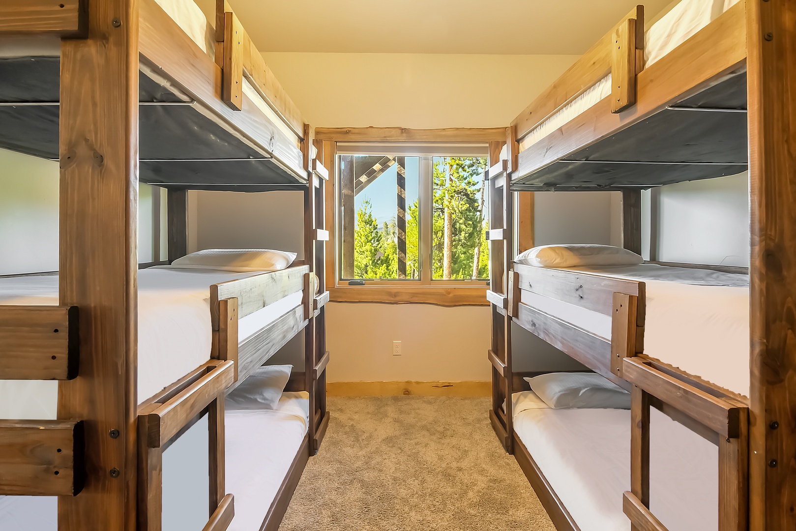 Wake up in your cozy bunk room where natural wood meets comfort, with a peaceful forest view to greet your mornings.