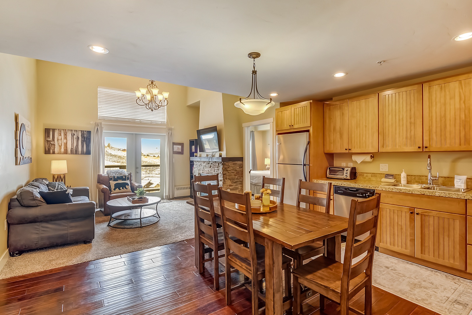 Your spacious open-concept retreat features warm wood finishes, a fully-equipped kitchen, and cozy living area where you can unwind after mountain adventures.