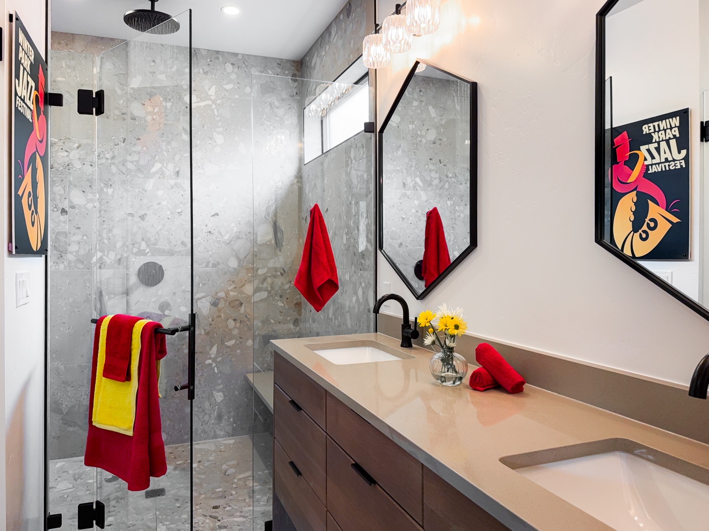 Refresh in your stylish bathroom with double vanities, a rainfall shower behind frameless glass, and chic modern fixtures. Bold pops of color add personality to the space.