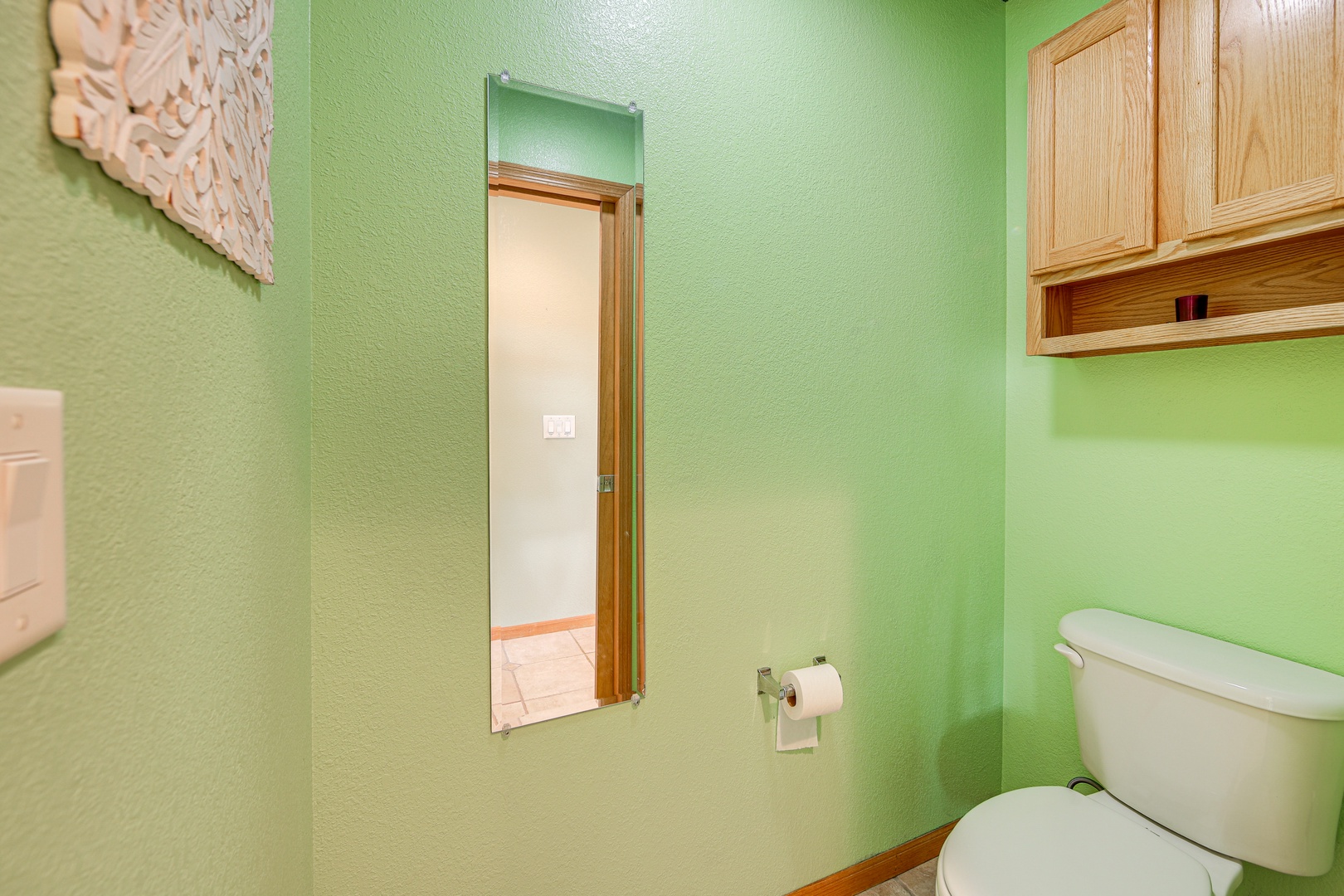 Your private bathroom features soothing green walls and warm wood accents, creating a peaceful retreat with all essentials at hand.