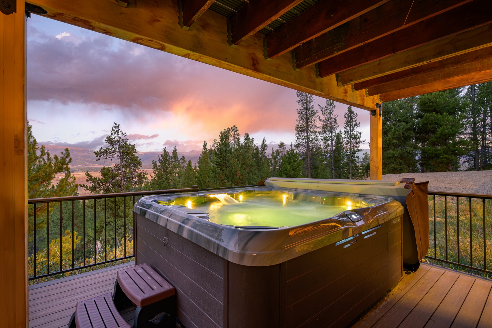 Soak under exposed beams as the sunset paints the sky in soft pastels, your private hot tub overlooking forested valleys and distant mountain ridges.
