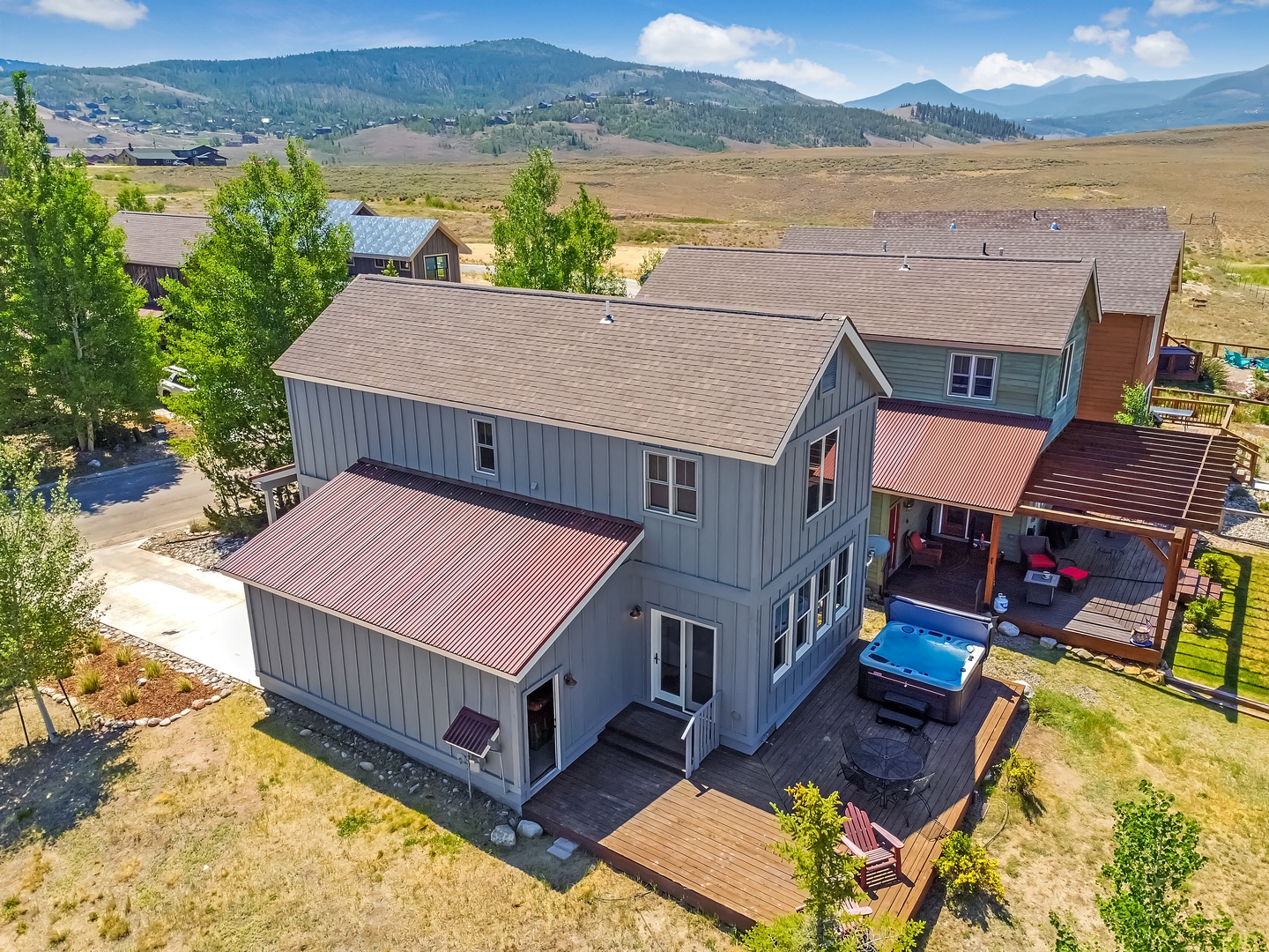 Aerial view of the property nestled in a peaceful mountain valley, surrounded by rolling hills and scenic landscapes, offering a secluded retreat with convenient access to nearby areas.