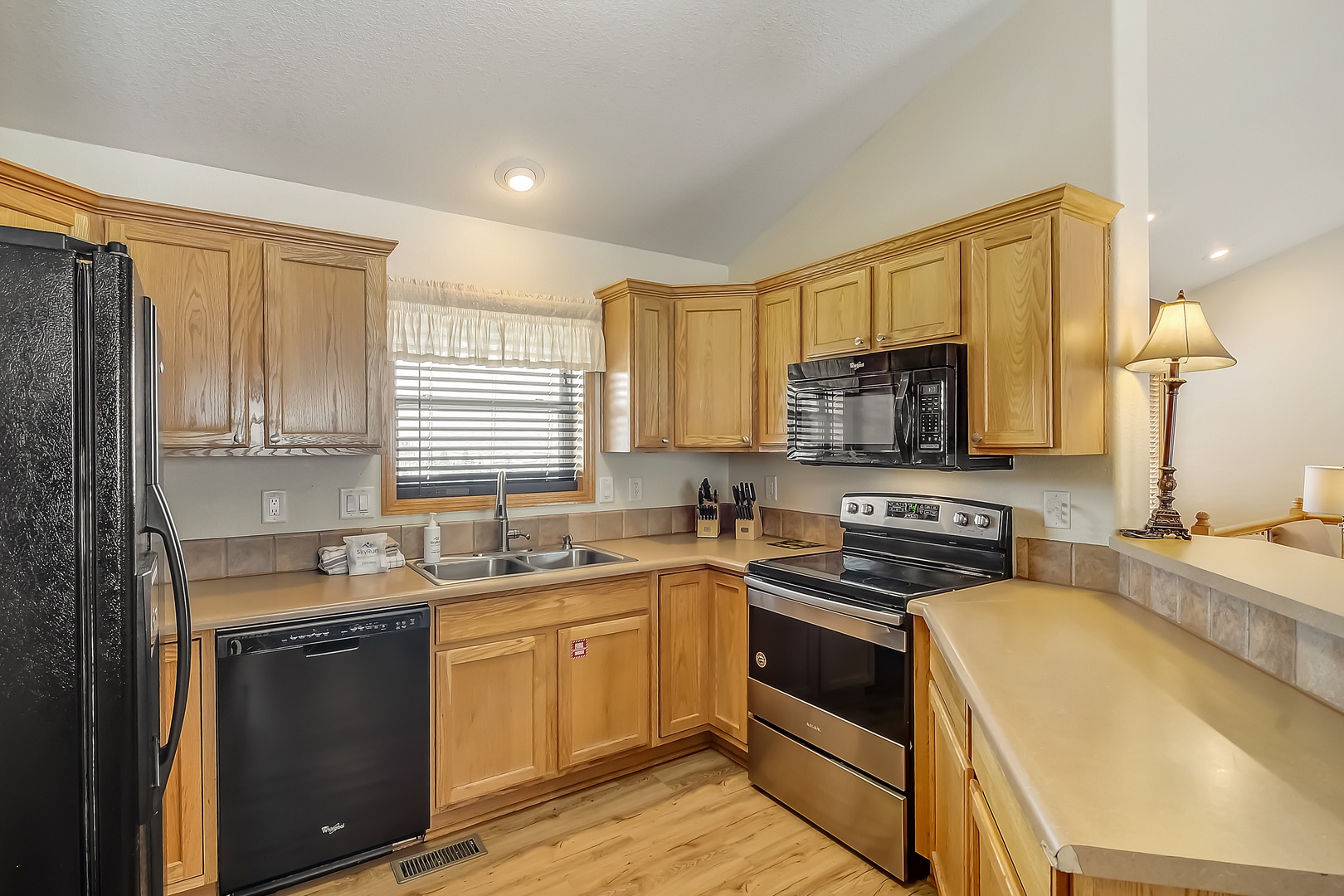 Your fully equipped kitchen awaits with warm wood cabinets, stainless appliances, and ample counter space for preparing memorable meals during your stay.