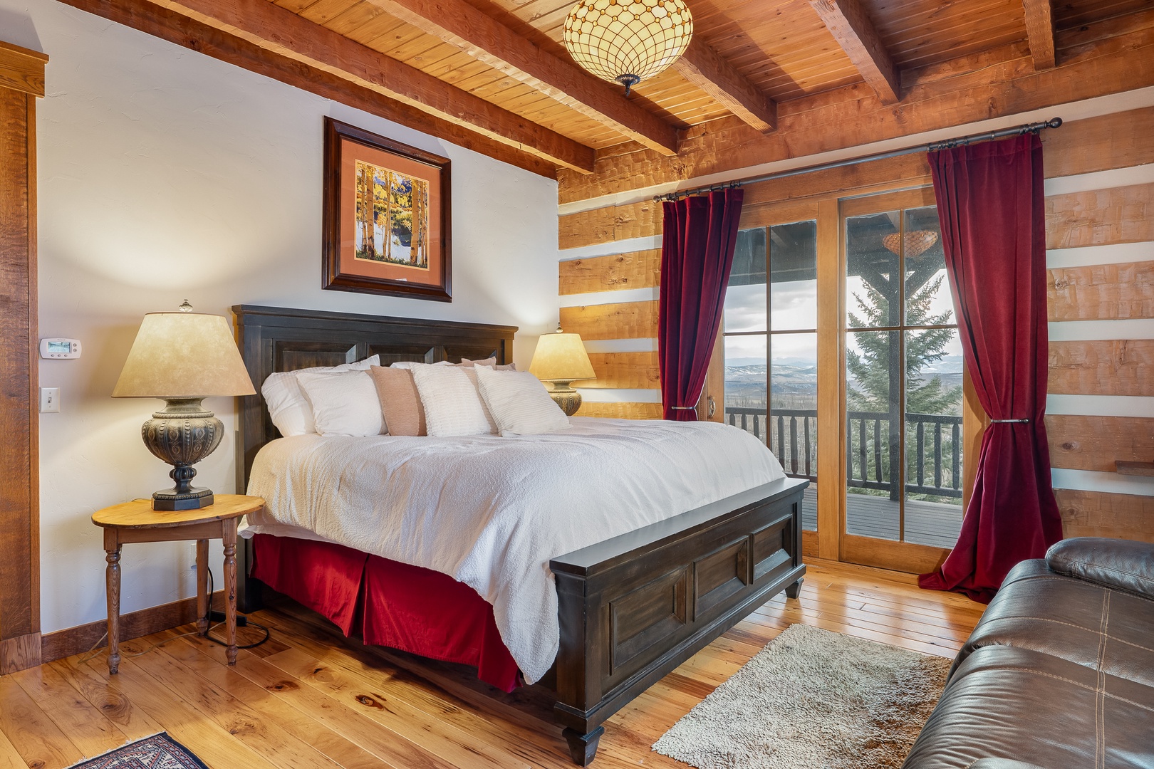 Unwind in your elegant log cabin bedroom with King Bed mountain views, on Main level