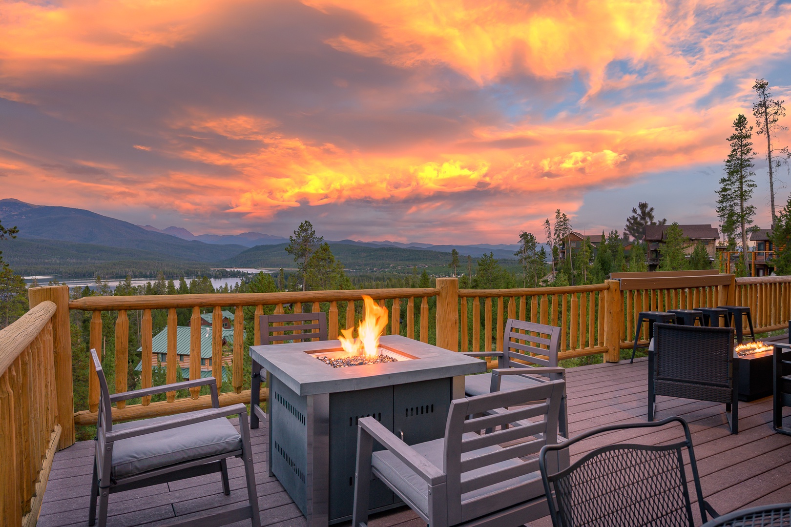 Relax on the deck with fire pit and seating, overlooking a lake and surrounding peaks.