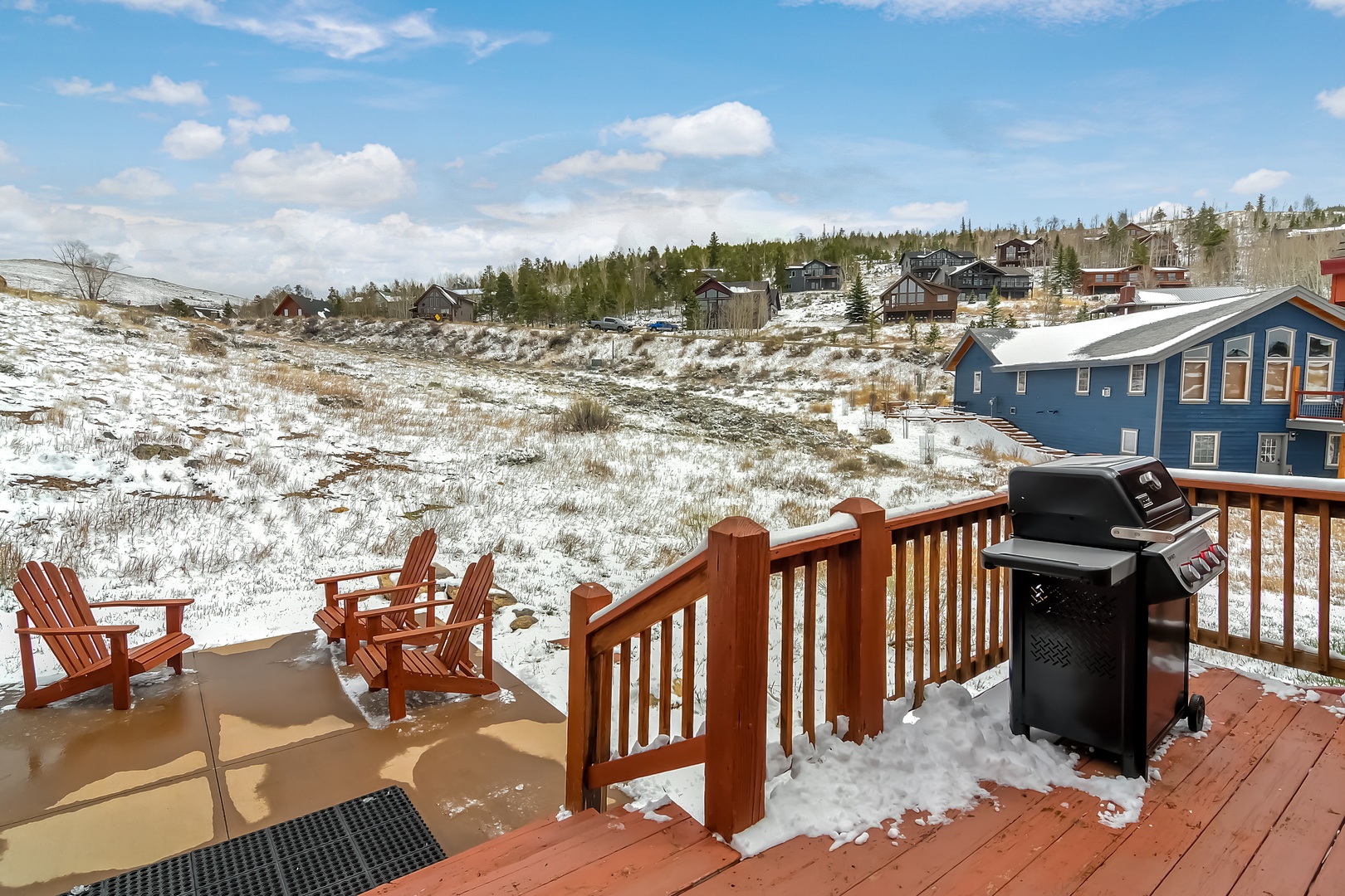 Your private deck overlooks snow-dusted hills and neighboring homes, perfect for grilling while taking in the peaceful winter landscape.