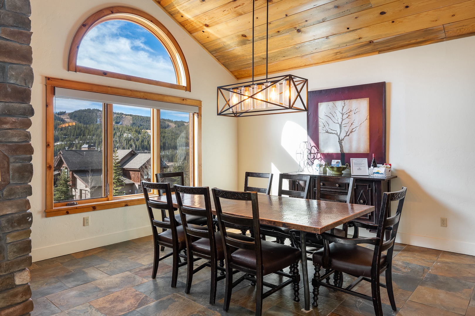 Savor memorable meals in this elegant dining room featuring stunning mountain views and warm wood beam ceilings.