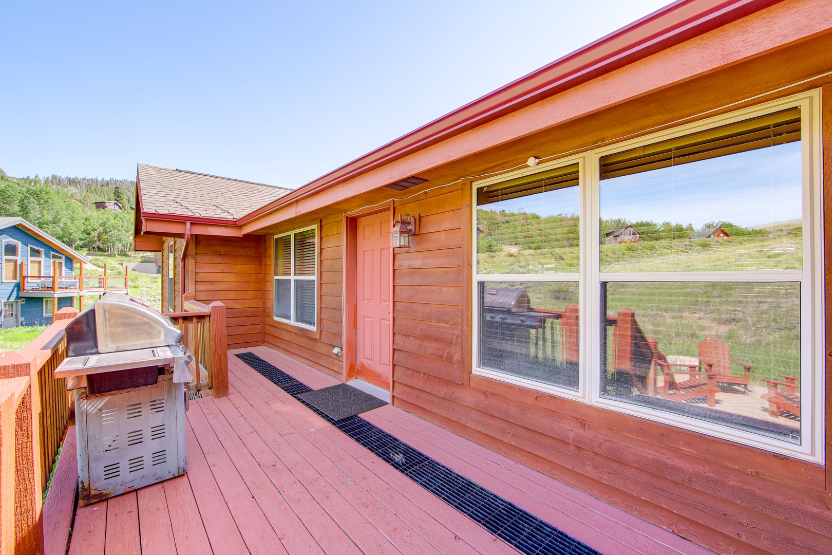 Your private deck features a BBQ grill and expansive windows showcasing rolling countryside views, perfect for outdoor dining and relaxation.