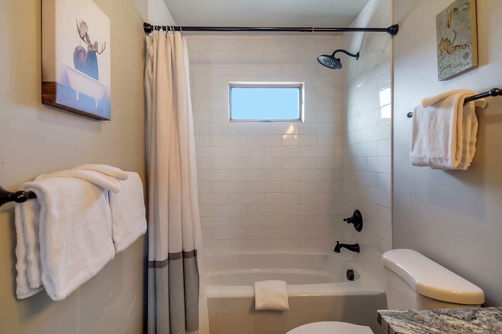 Unwind in your private bathroom featuring a relaxing tub-shower combo with fresh towels and natural light streaming in.