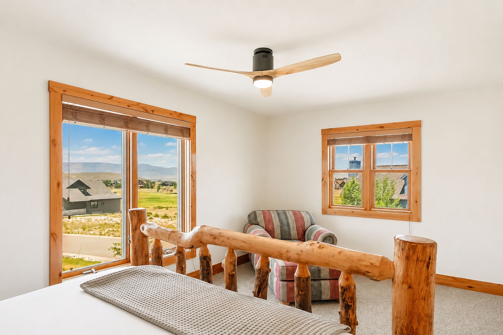 Wake up to sweeping mountain vistas framed by rustic pine. Your cozy retreat features handcrafted log furniture and a ceiling fan for ultimate comfort.