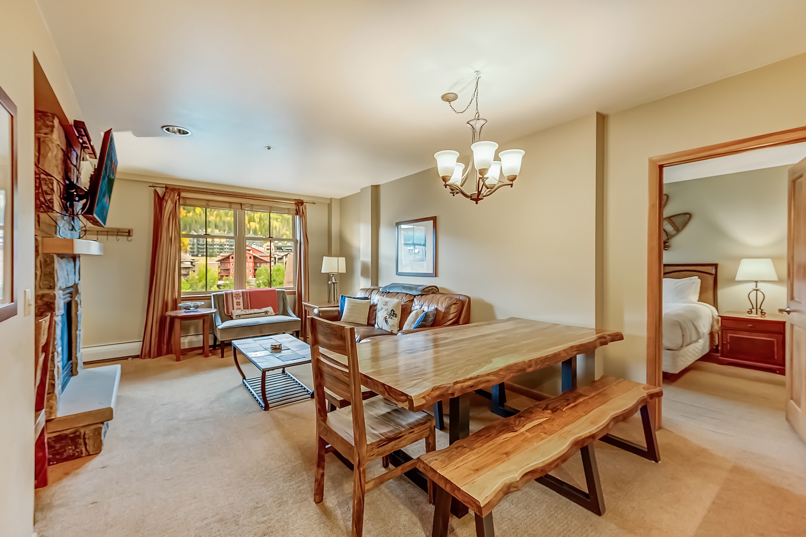 Your cozy mountain retreat features a spacious living and dining area with natural wood furnishings and warm lighting, perfect for gathering with loved ones after a day of adventure.