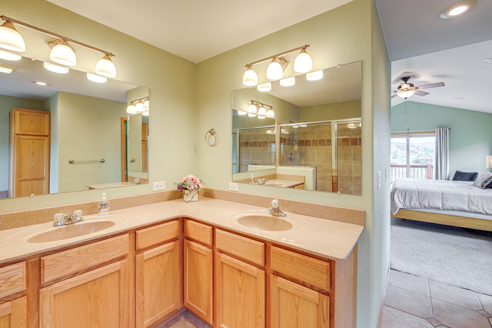 Your spacious master bathroom features dual vanities with warm wood cabinetry, perfect for morning routines together.