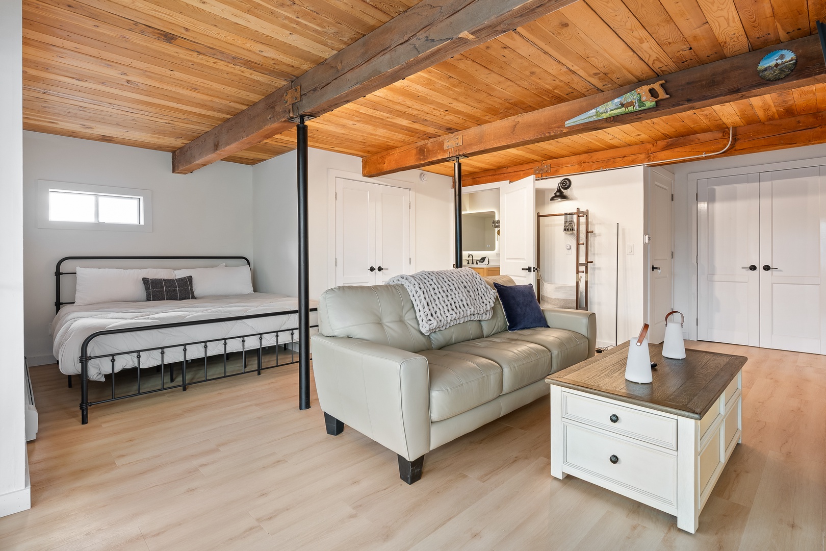 Settle into your cozy primary king suite  with vaulted wood-beam ceilings.