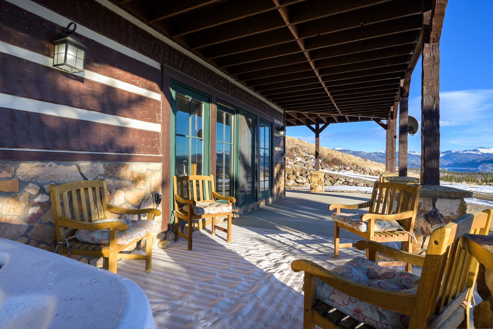 Rustic covered patio with mountain views offers perfect spot to enjoy morning coffee and breathtaking scenery.