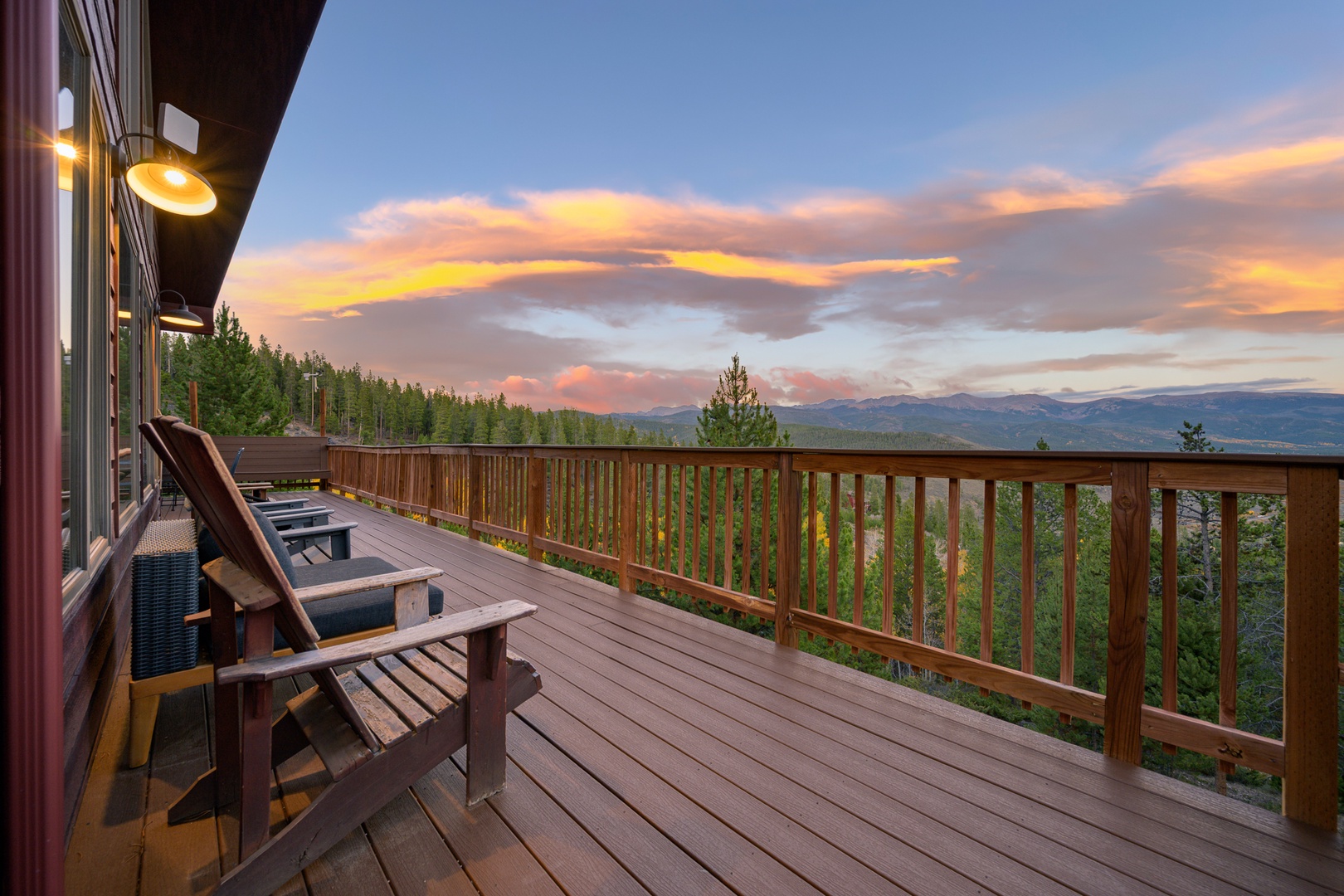 Settle into your private deck chair as the day melts into a breathtaking mountain sunset, painting the sky in warm golds and pinks above the forested valley below.