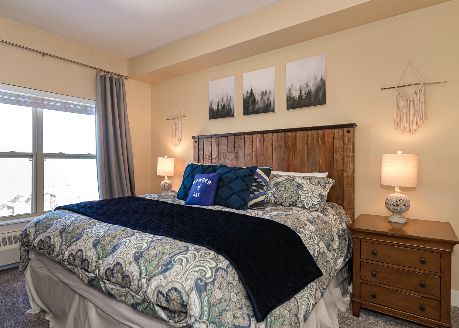 Unwind in your cozy bedroom with rustic charm—soft linens, warm lighting, and peaceful forest artwork create the perfect retreat.