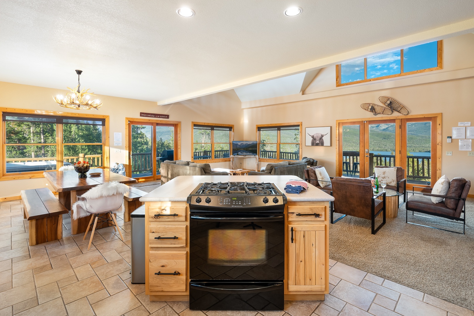 Gather around this open-concept space where floor-to-ceiling windows frame sweeping mountain vistas. Your kitchen flows into cozy living areas—perfect for morning coffee or evening meals with those unforgettable views at every turn.