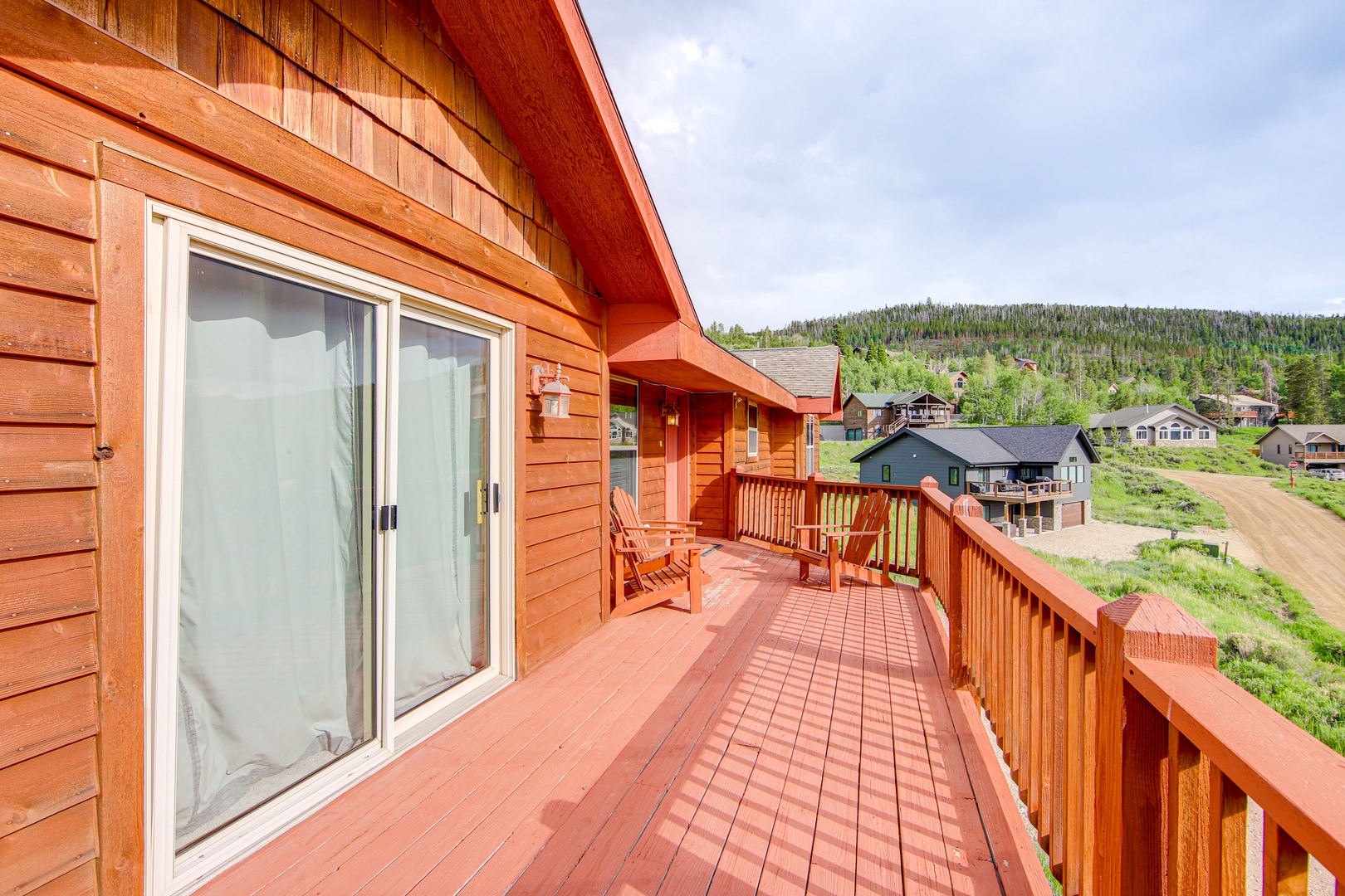 Spacious wooden deck with mountain views provides the perfect spot to unwind and soak in the peaceful neighborhood atmosphere.