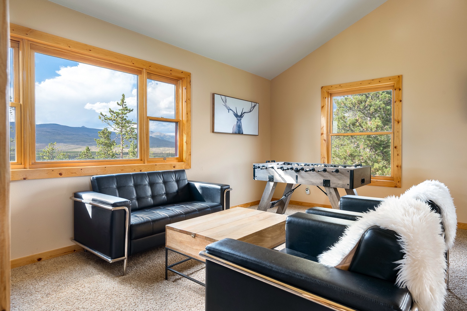 Loft area with sweeping mountain vistas. Challenge friends to foosball, sink into sleek seating, and let natural light fill your getaway.