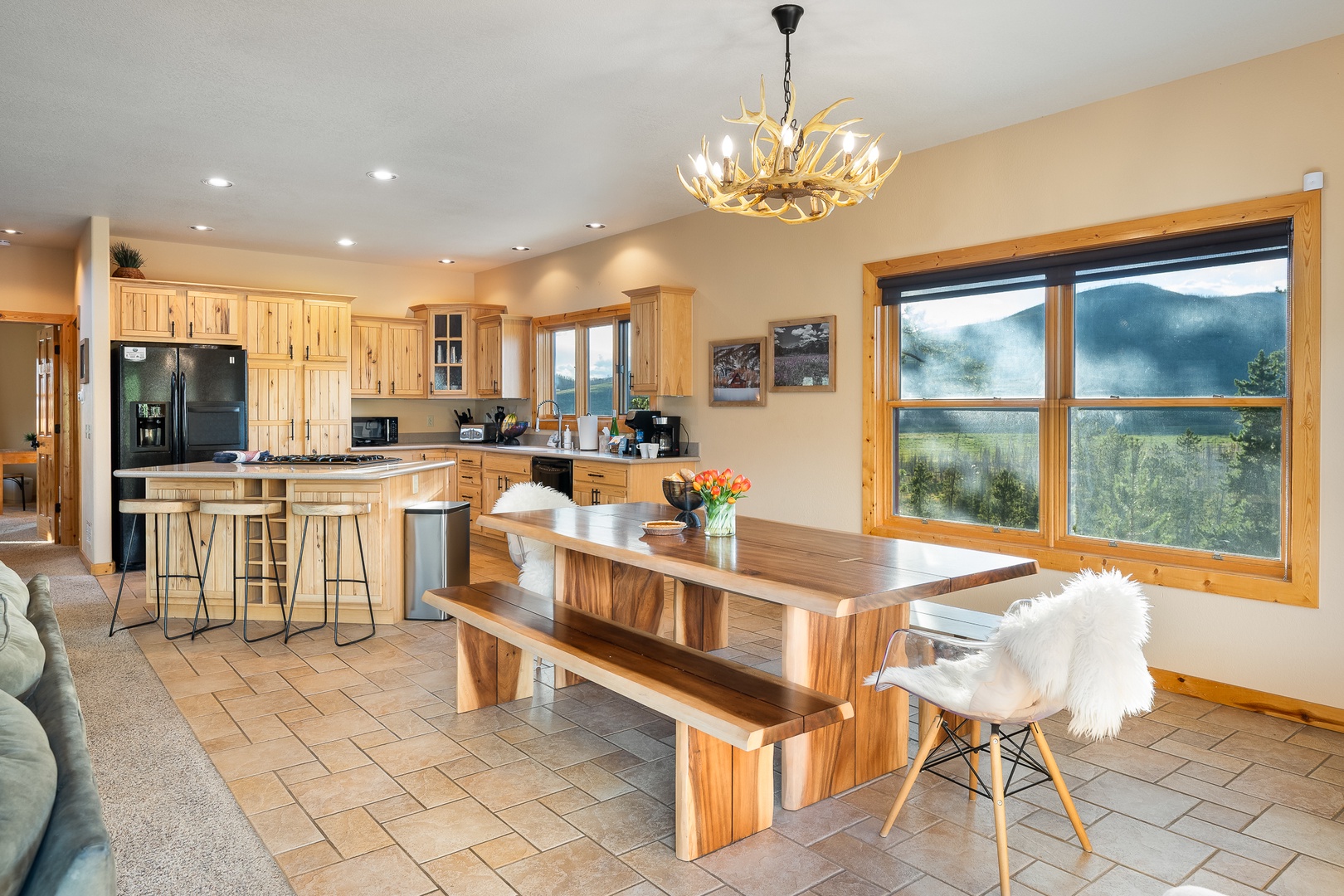Your bright open kitchen and dining area invites you to gather around the handcrafted wood table with mountain views framing every meal through expansive windows.