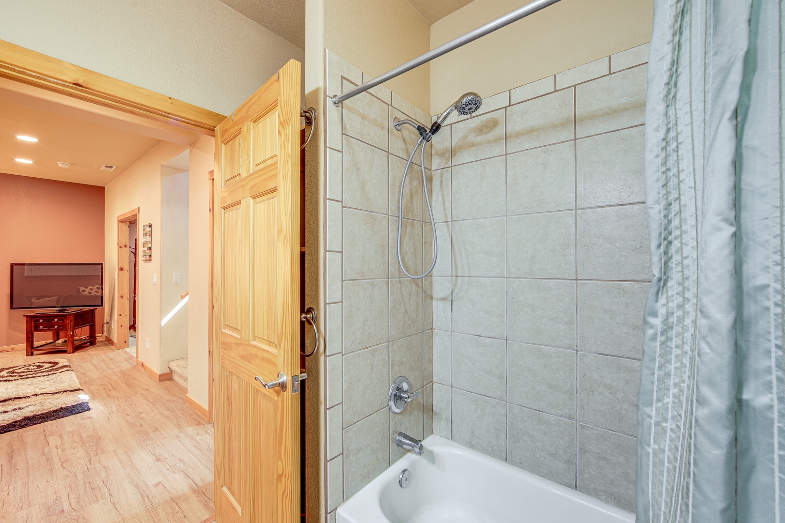 Refresh in your tiled shower-tub combo with modern fixtures and convenient curtain for privacy.