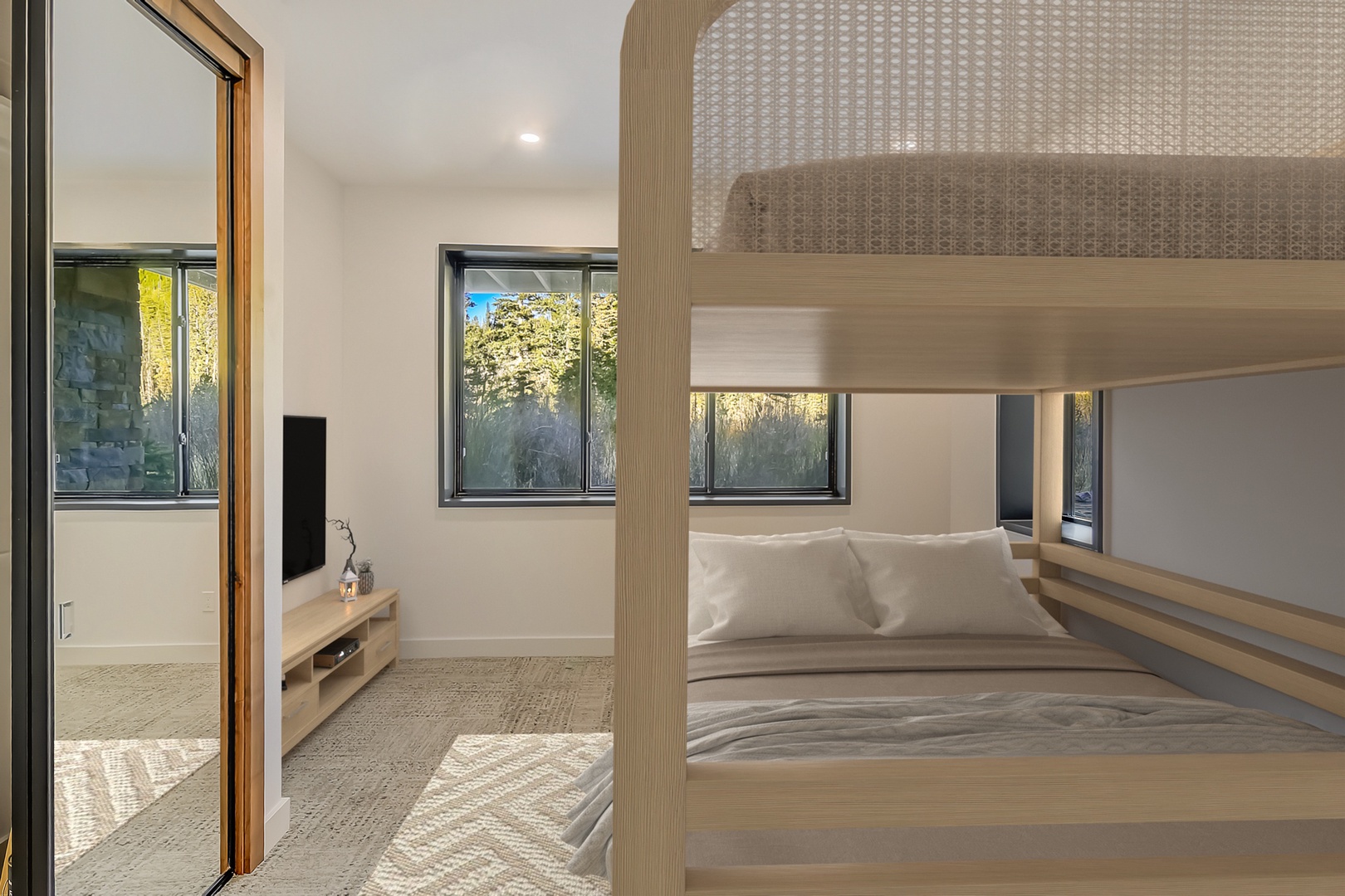 Cozy up in your modern bunk bed with crisp linens while enjoying natural light streaming through multiple windows.