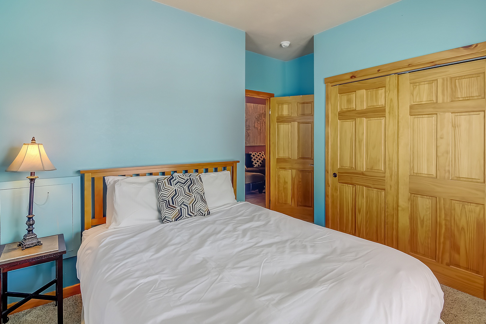 Rest peacefully in this cozy bedroom with soothing blue walls and ample storage for your belongings.