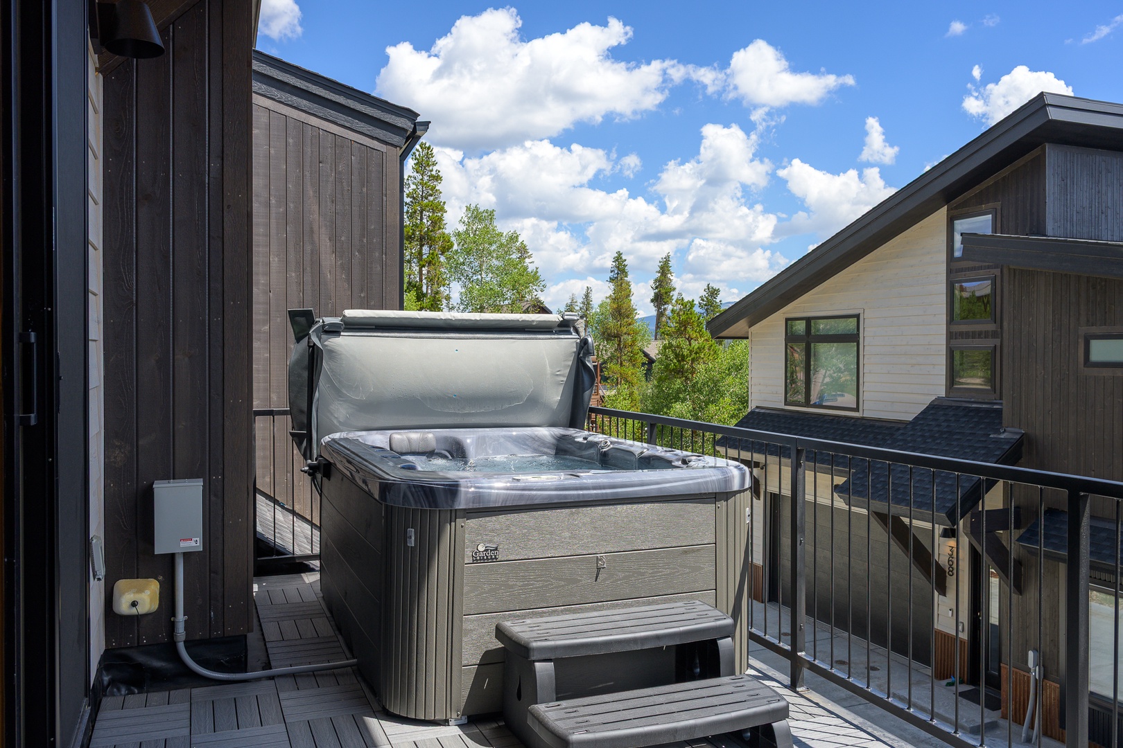 This private balcony features a spacious hot tub where you can soak under open skies. Surrounded by mountain views and trees, it's the perfect retreat after a day of exploring.