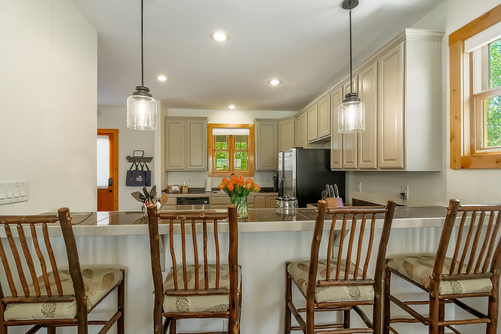 Pull up a chair to the spacious island where fresh flowers and modern pendant lights set a welcoming tone for your mornings and meals together.