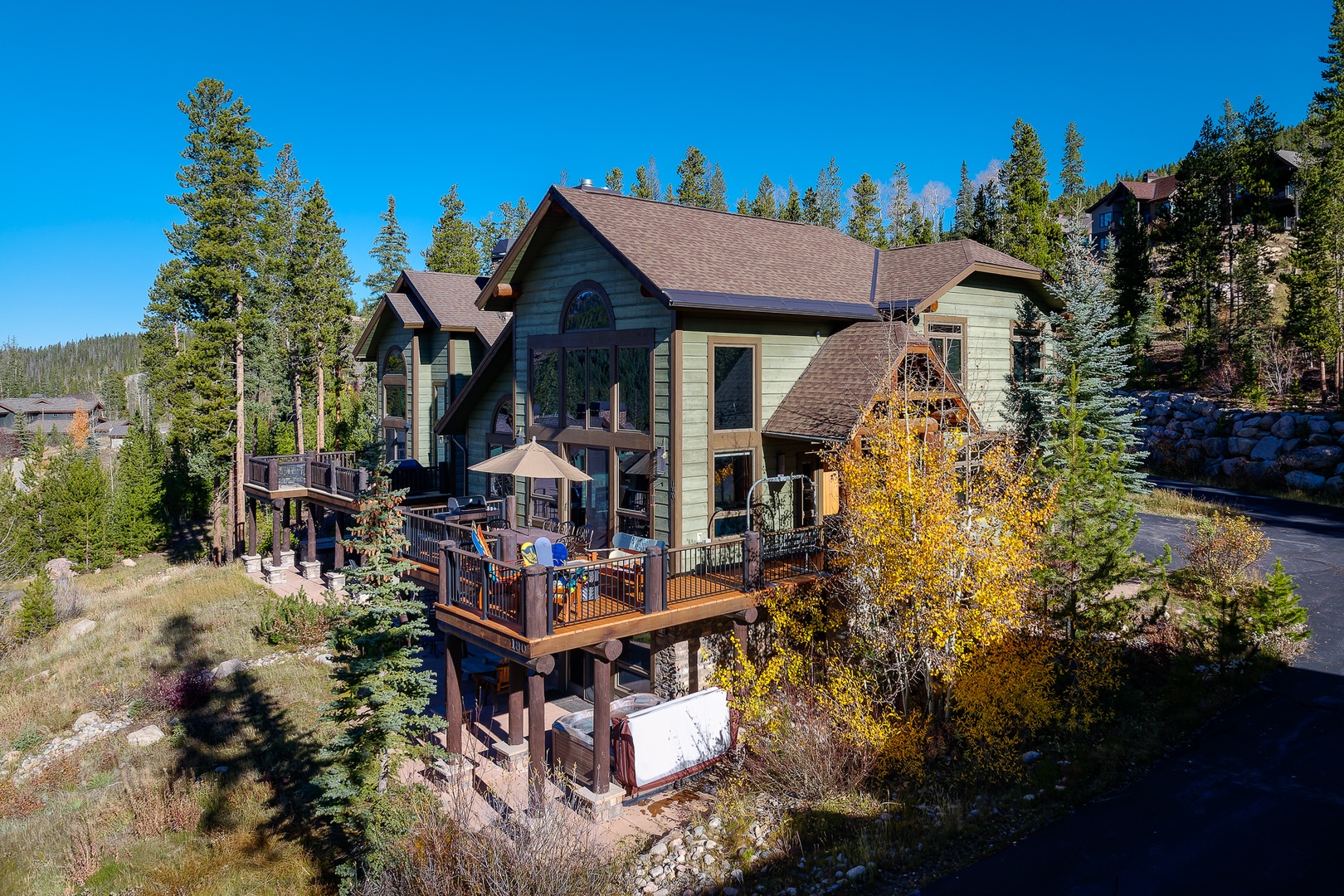 Mountain retreat nestled among towering evergreens with autumn aspens painting the landscape in golden hues.