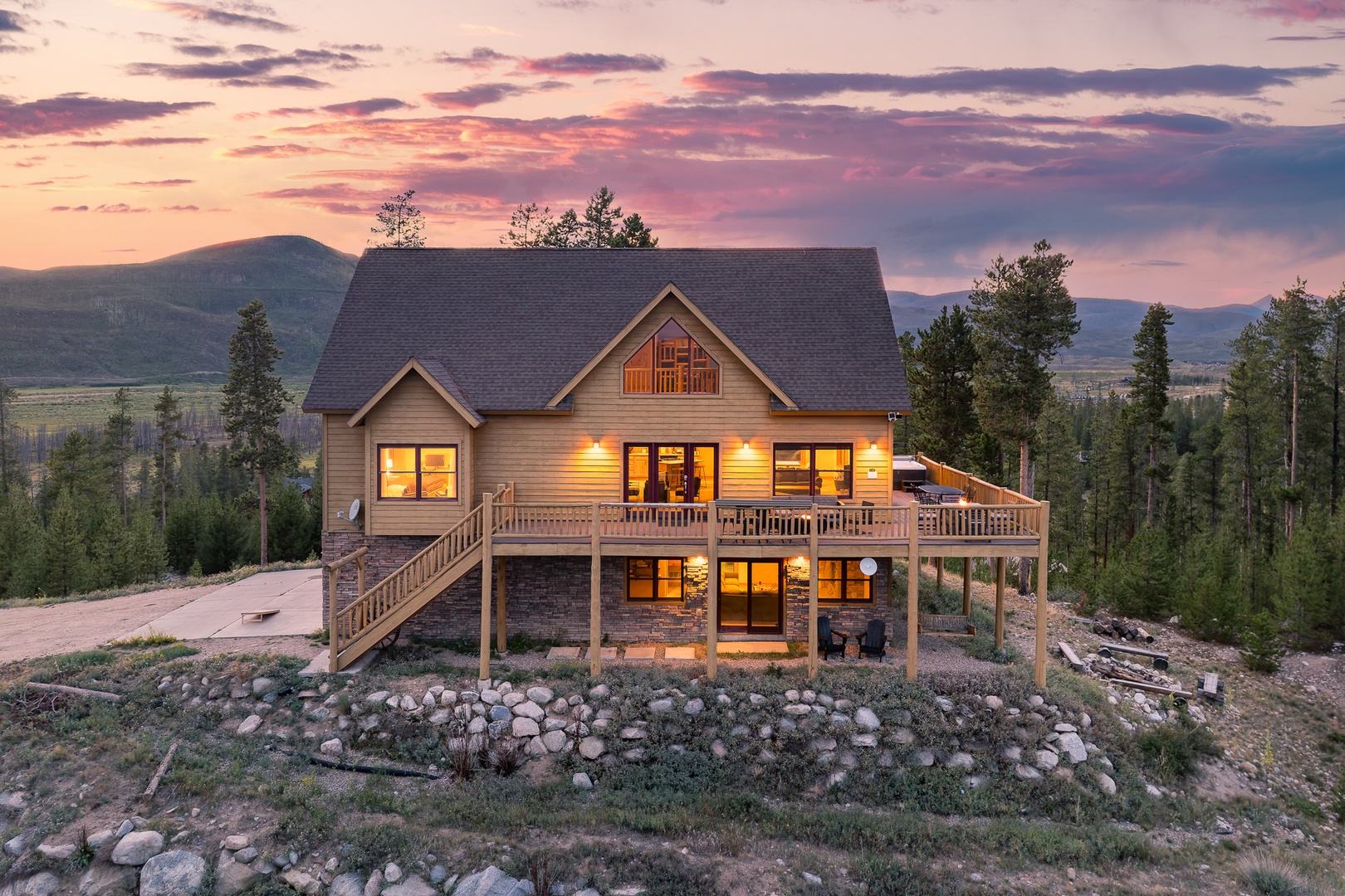 A stunning mountain retreat nestled among pines, glowing warmly at dusk as the sun sets over rolling peaks—an idyllic backdrop for your Colorado getaway.