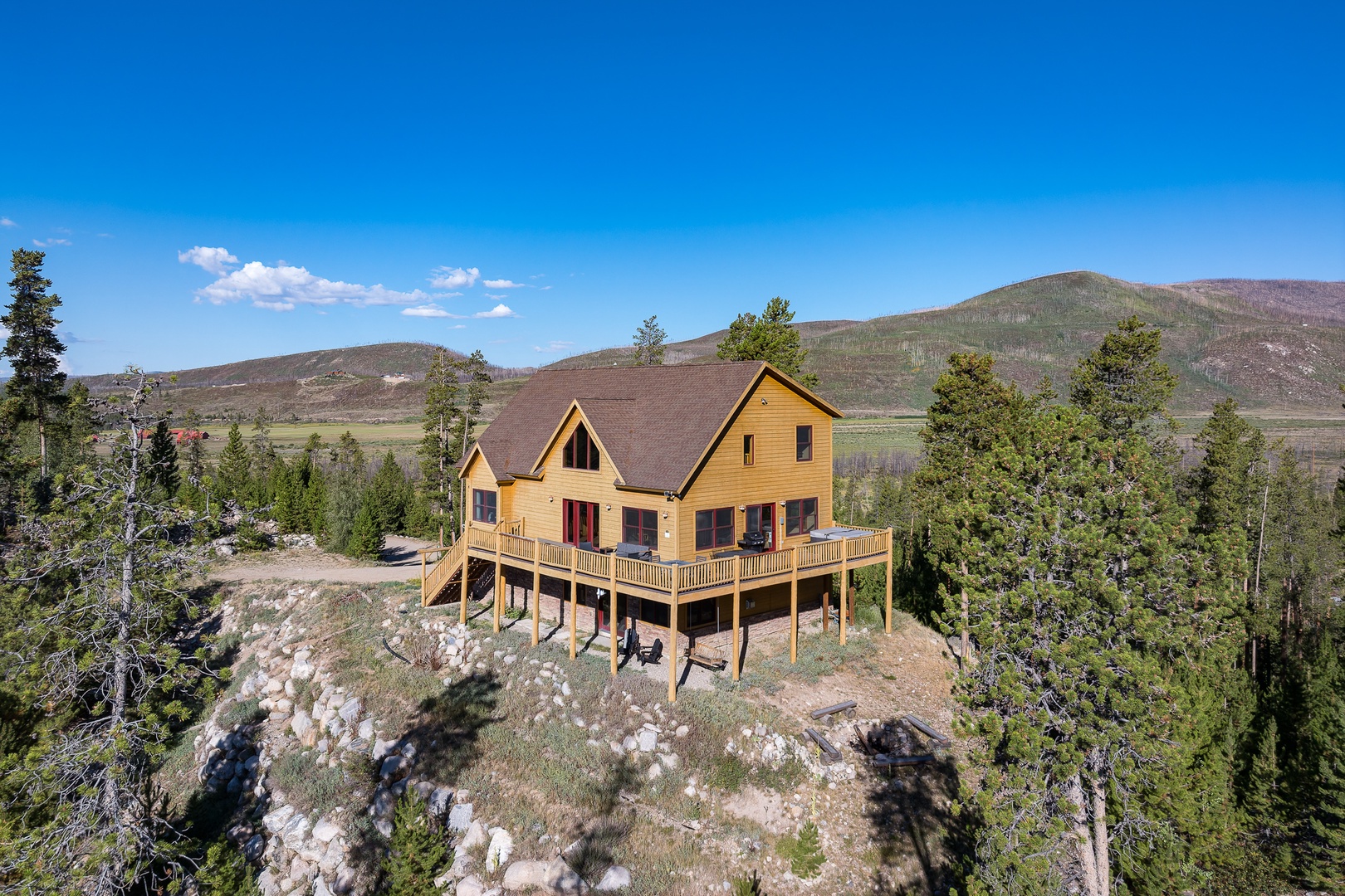 A secluded mountain retreat with wrap-around deck, nestled among pine trees and framed by rolling hills. The perfect blend of rustic charm and breathtaking natural beauty.