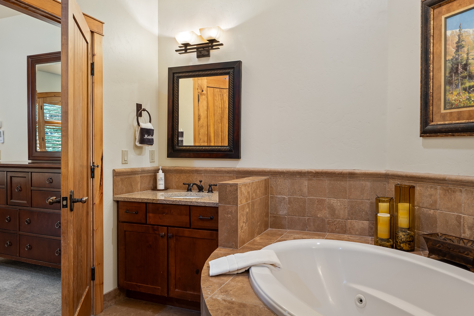 Unwind in your private spa-like bathroom, where warm wood tones and a deep soaking tub create the perfect retreat for relaxation.