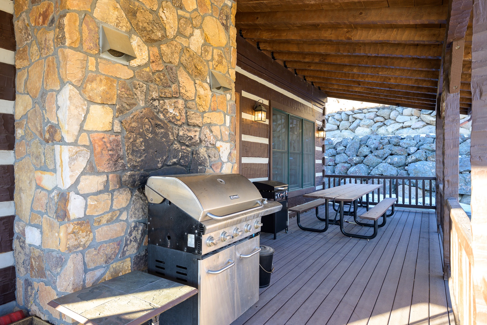 Fire up your mountain retreat BBQ on this rustic covered deck, perfect for grilling while taking in stunning stone views.