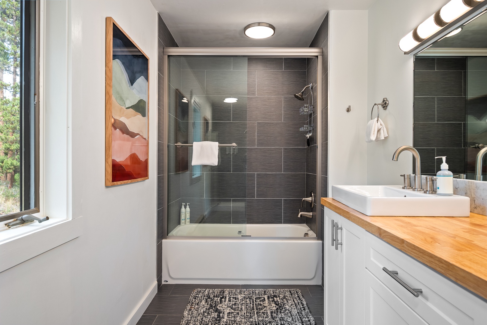 Refresh in your sleek, modern bathroom, where natural light meets warm wood and cool tile for a spa-like experience every morning.