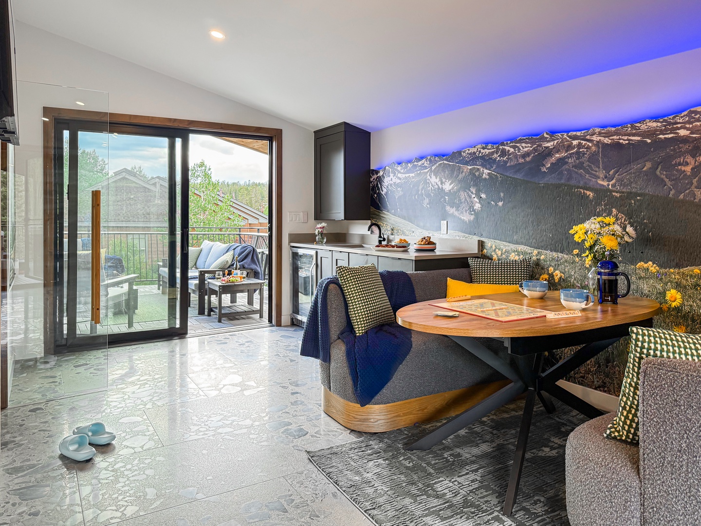 Step into your sunlit dining area, where fresh flowers brighten the table and glass doors open to your private balcony. The modern kitchen awaits your morning coffee ritual.